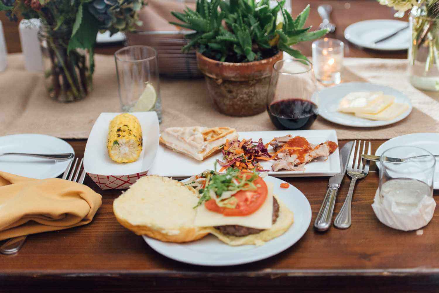 017-kate-eldar-lake-house-inn-rehearsal-dinner-philadelphia-wedding-photographer-alison-dunn-photography-photo A table setting with a burger and corn on the cob.