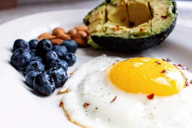 pexels-jenna-hamra-1305063 An avocado, blueberries, and an egg on a plate offer a unique wedding breakfast experience.